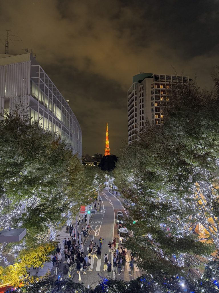 Keyakizaka Street lined with trees in white winter lights, with an orange Tokyo Tower glowing at the end of the road
